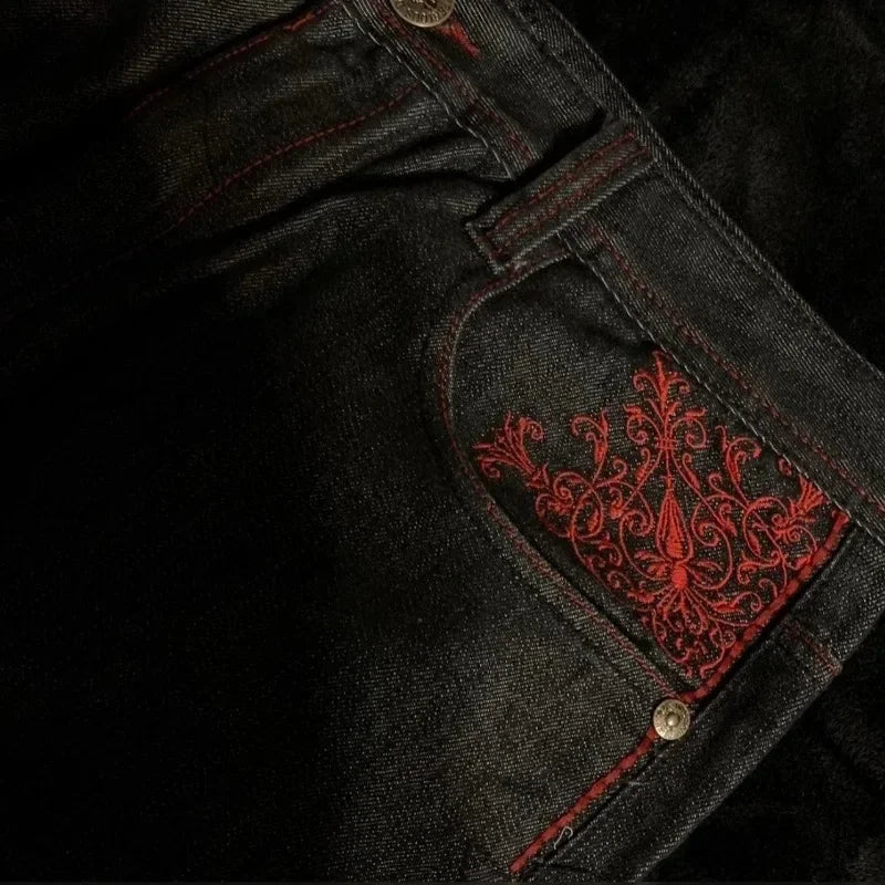 Black denim jacket with red embroidery on a dark background