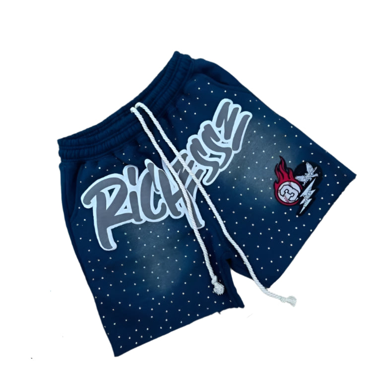 Navy blue shorts with 'Richness' text and logo on a gray surface