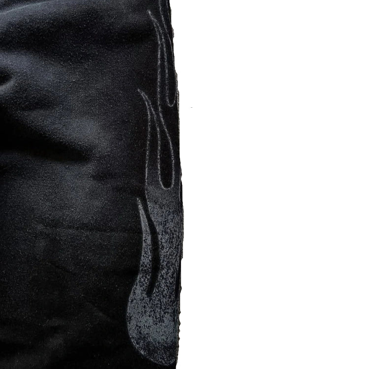 Close-up of textured fabric with a flame design on a dark background