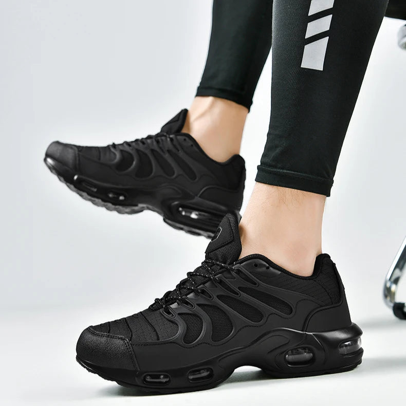 Black athletic shoes worn with black leggings on a light gray background