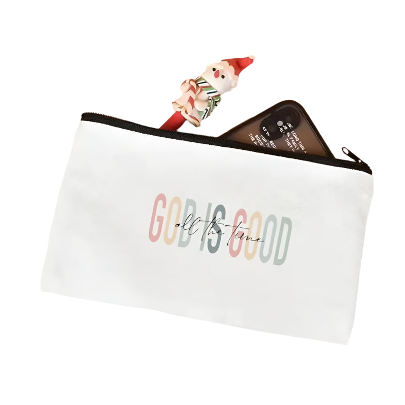 White pouch with 'GOD IS GOOD all the time' text on a light pink surface.