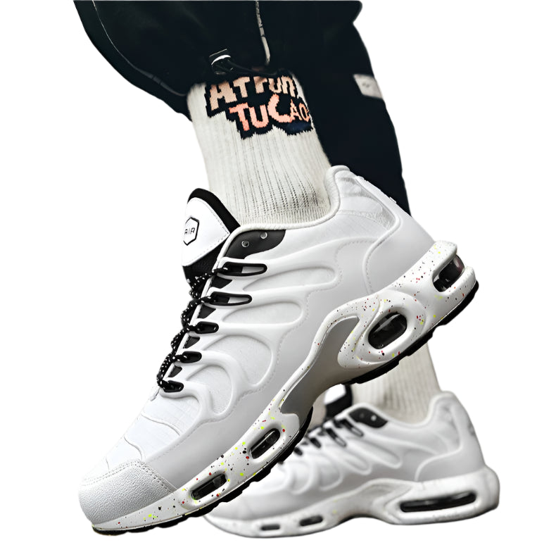 White sneakers with black accents worn on a blurred city street background