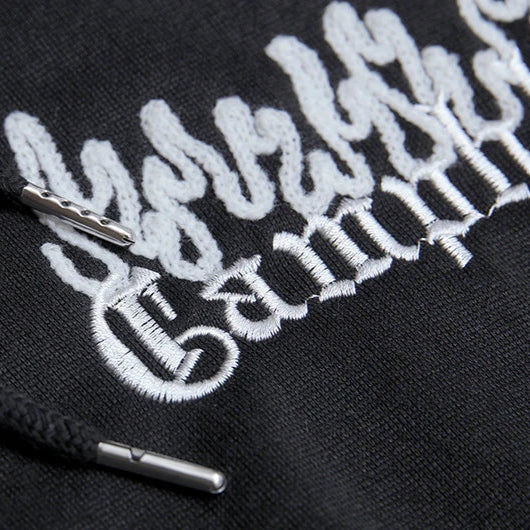 Black hoodie with white embroidered text and logo on a dark background