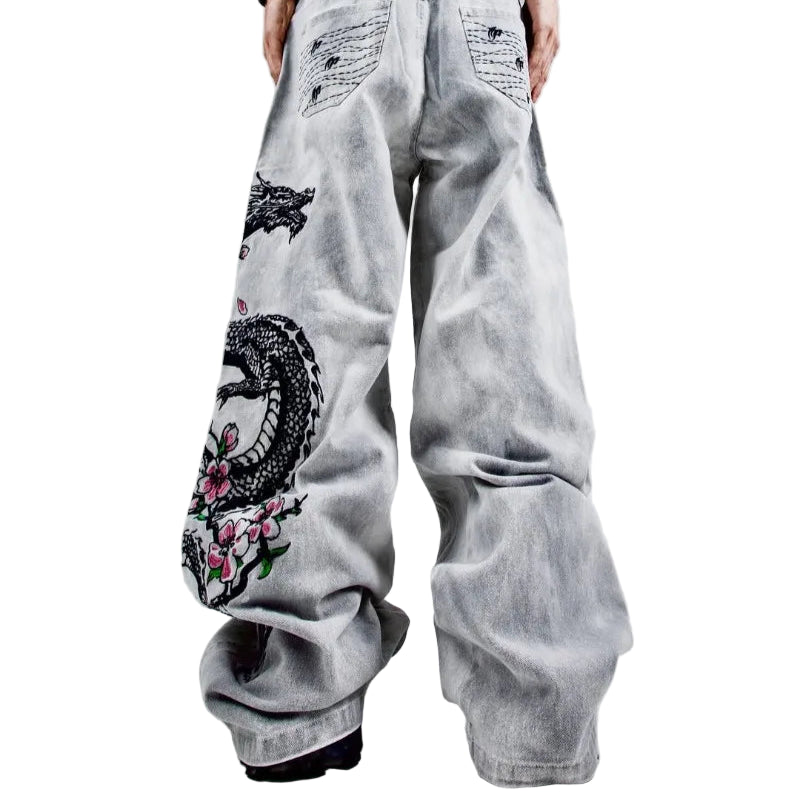 Light gray jeans with artistic designs on a plain background