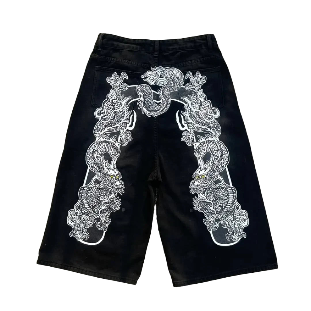 Black shorts with white embroidery on a concrete surface
