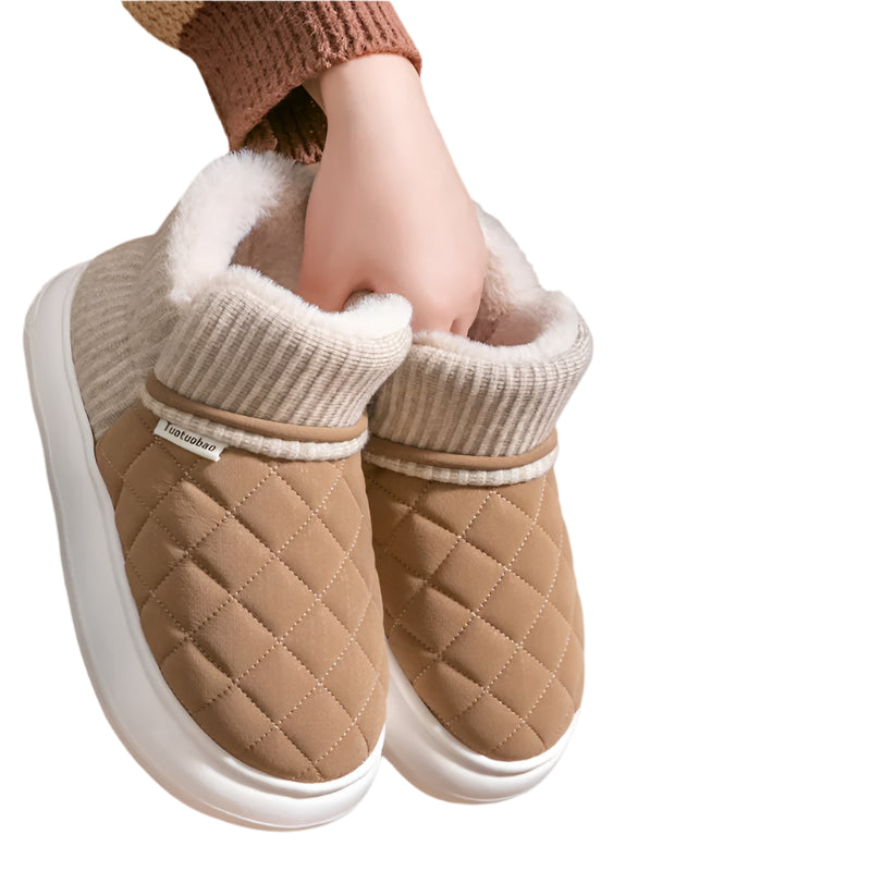 Brown quilted shoes with white soles held by a person, on a brown background with text 'keep warm Cold proof'.