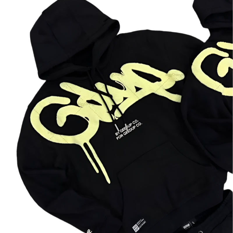 Black hoodie with yellow logo on a gray surface