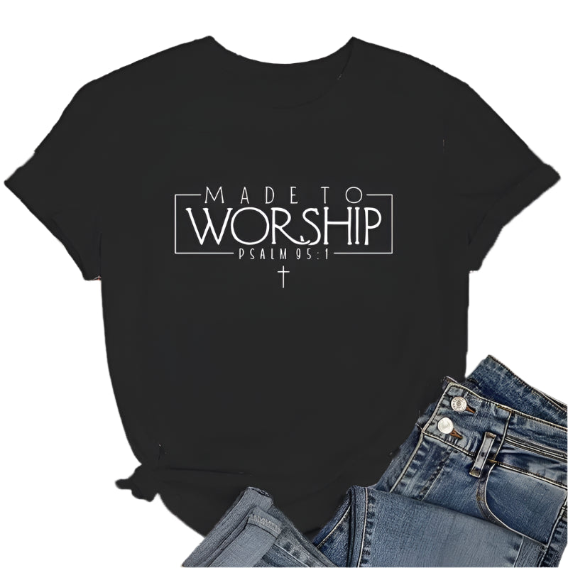 Black t-shirt with 'Made to Worship' text on a wooden surface with jeans and sneakers.
