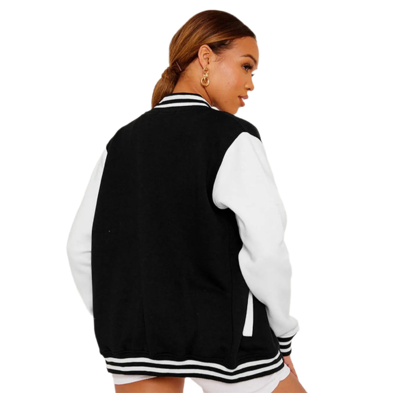Woman wearing a black and white varsity jacket with a white top and shorts on a light gray background.