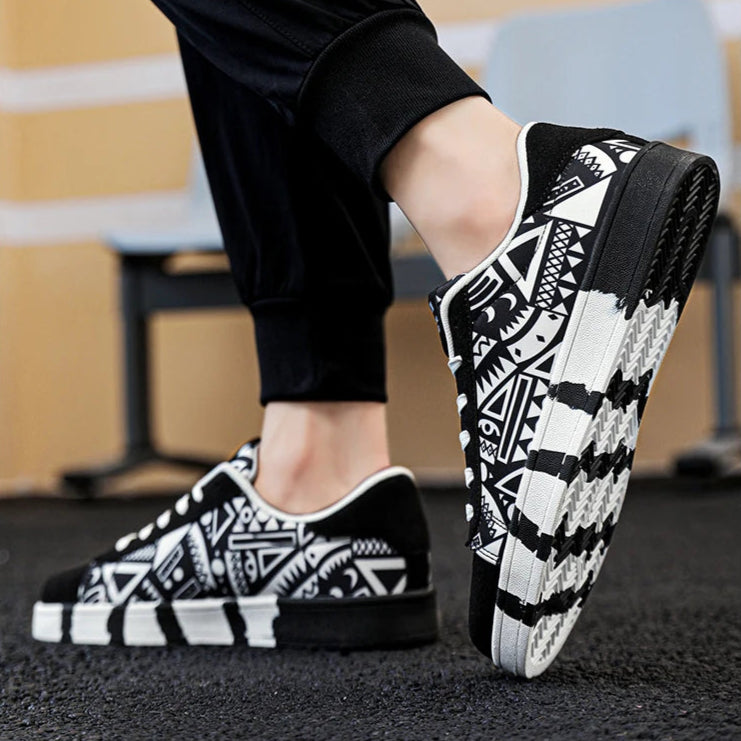 Black and white patterned sneakers worn with black pants on a blurred background