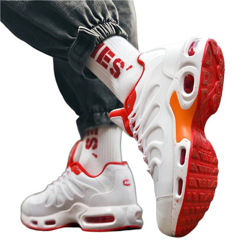 White sneakers with red soles and orange accents worn by a person on a blurred background