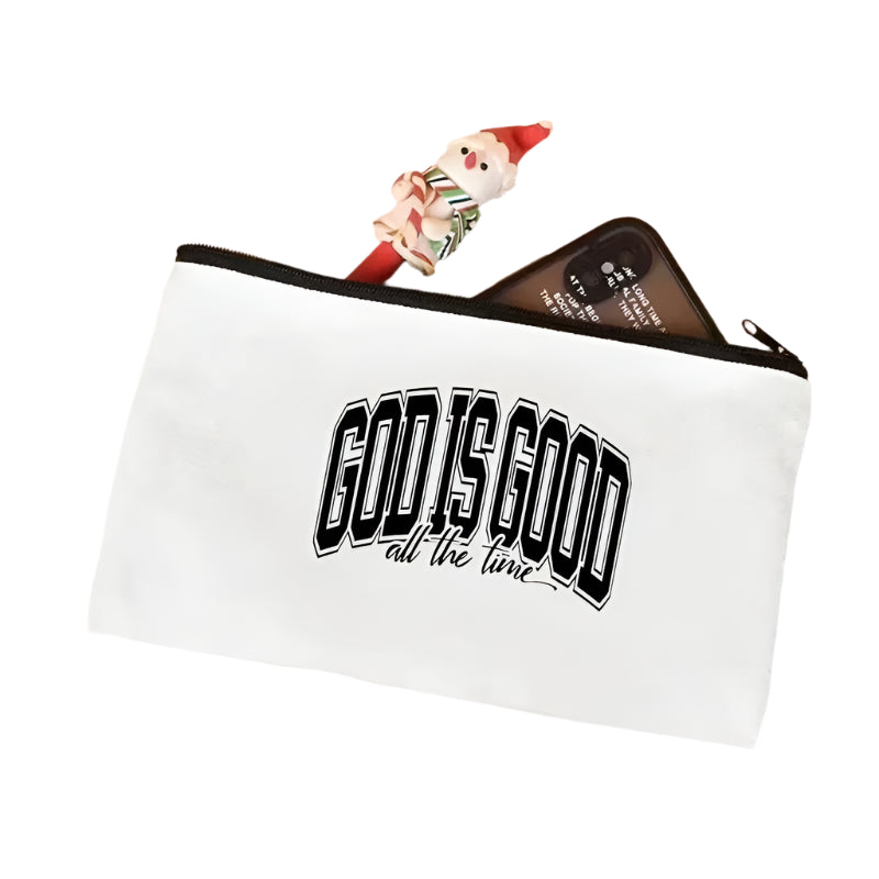 White pouch with 'GOD IS GOOD all the time' text on a light pink surface.