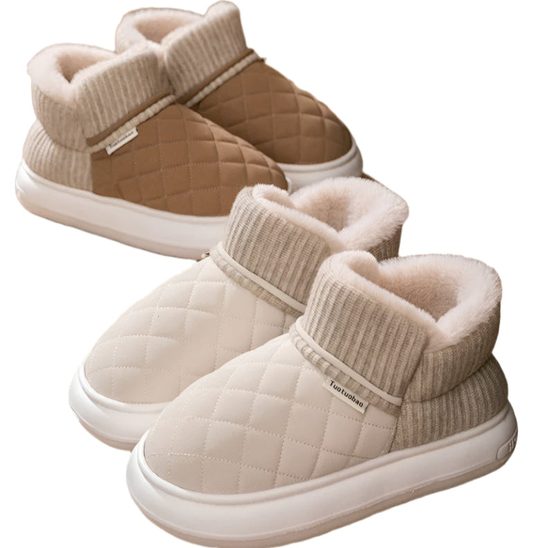 Pair of warm high-top slippers with soft touch label on a wooden floor.