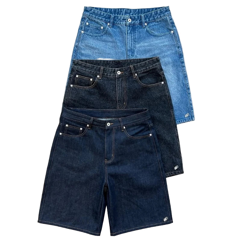 Three pairs of denim shorts in different shades on a concrete surface