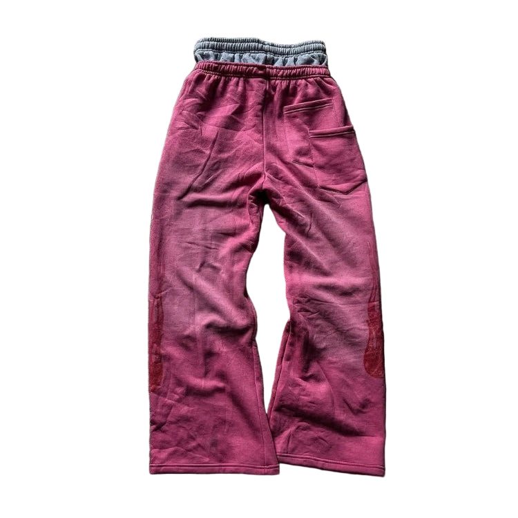 Pink sweatpants on a textured gray surface