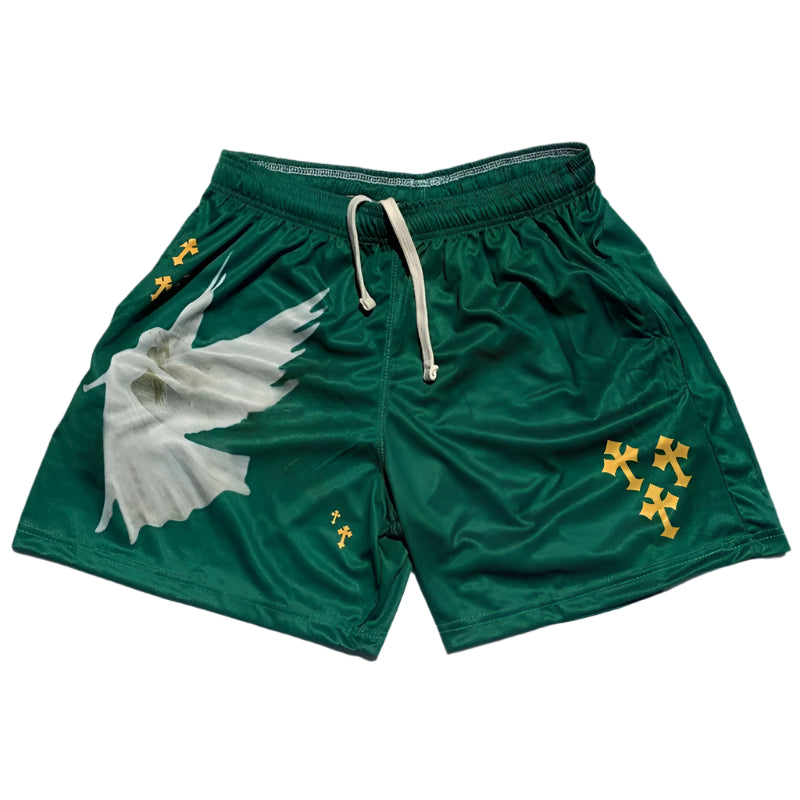 Green shorts with a white shell design and yellow crosses on a gray surface