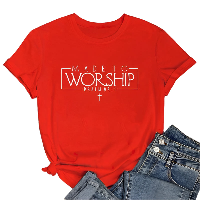 Red t-shirt with 'Made to Worship' text on a wooden surface with jeans and sneakers.