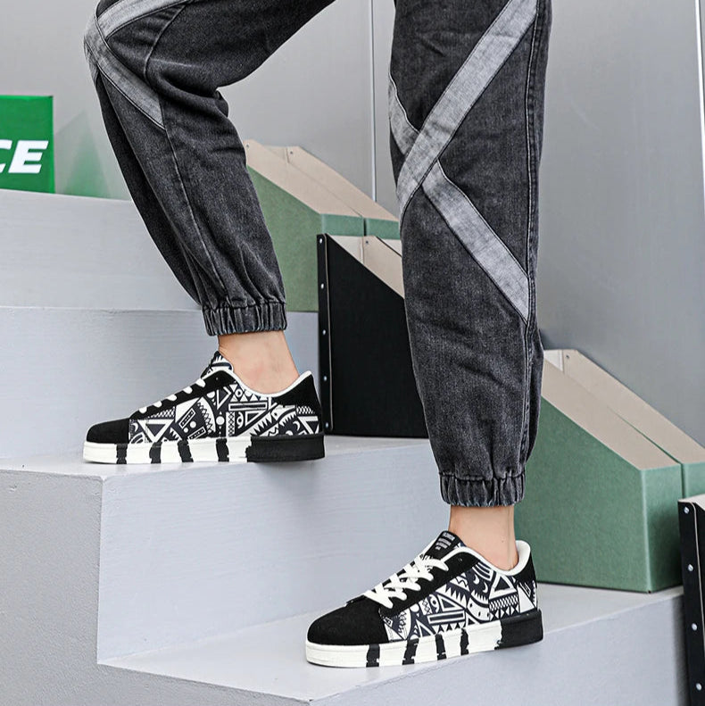 Person wearing black and white checkered sneakers with gray pants on a white background