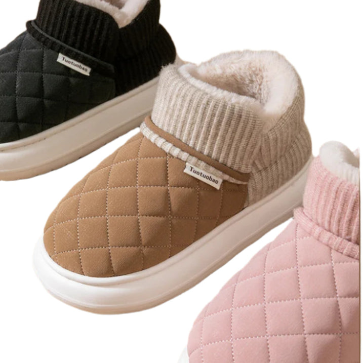 Three pairs of quilted ankle boots in black, brown, and pink on a wooden surface.