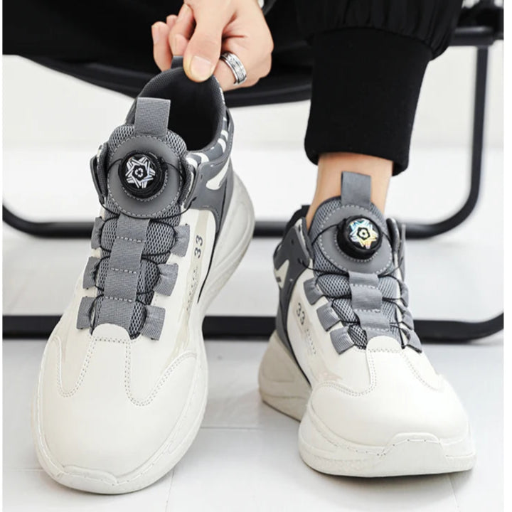 Person wearing gray and white sneakers with decorative elements on a white background