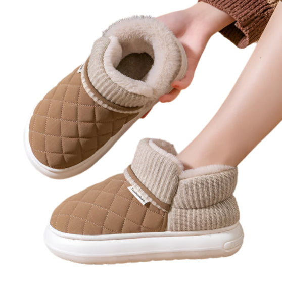 Brown quilted ankle boots with white soles on a wooden floor.