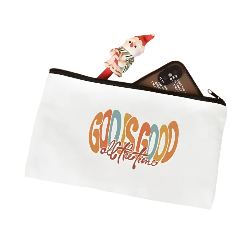 White pouch with 'God is Good all the time' text on a light pink surface.
