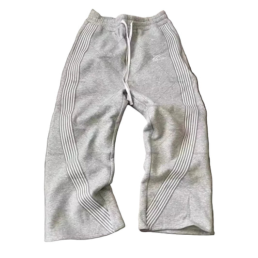 Gray sweatpants with white stripes on a wooden floor