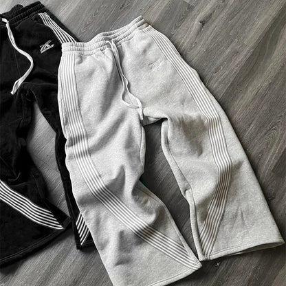Gray sweatpants with white stripes on a wooden floor