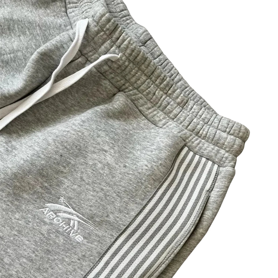 Gray sweatpants with a brand logo on a wooden surface