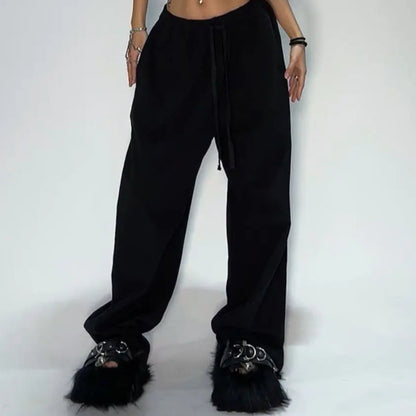 Person wearing a black outfit with fur-lined shoes on a white background