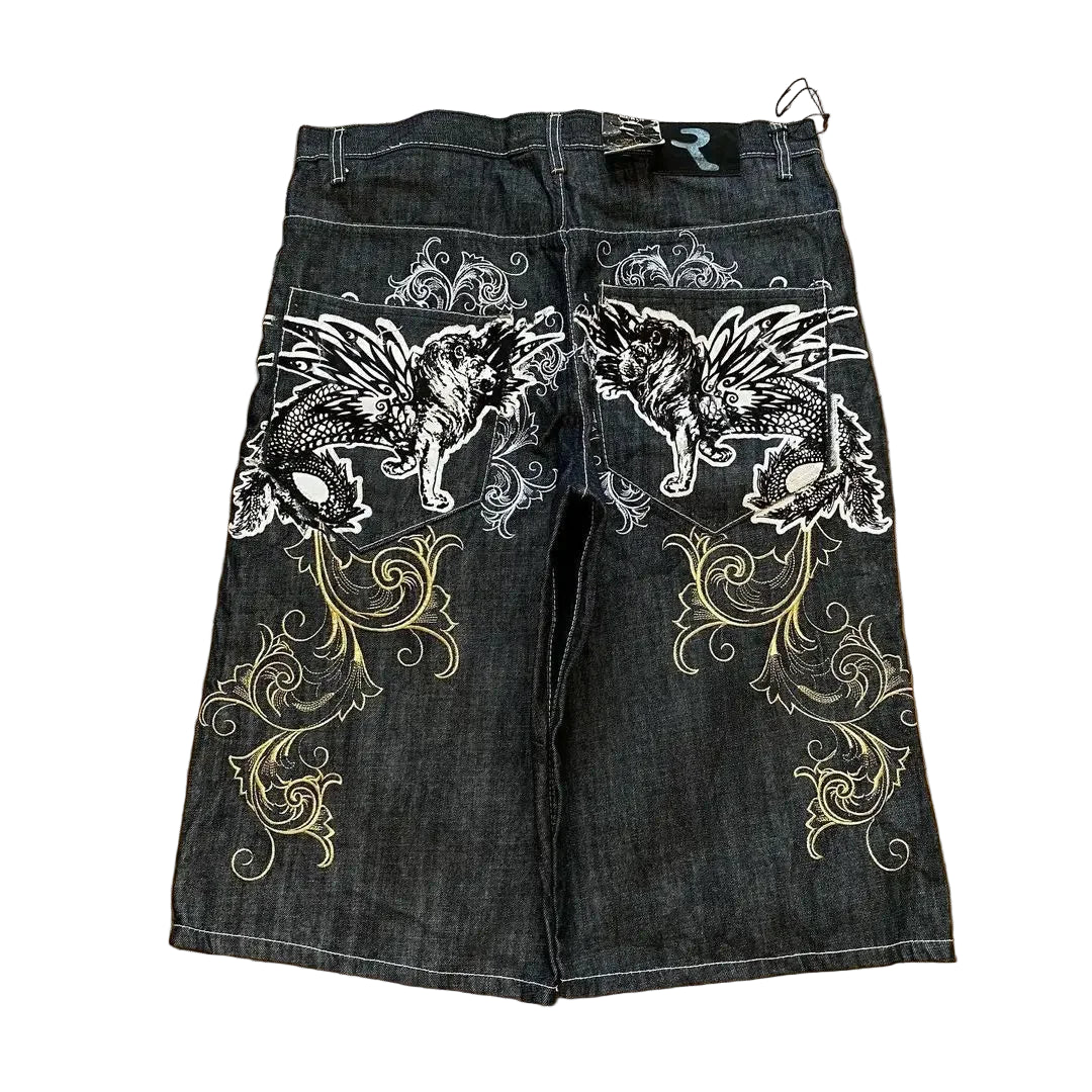 Denim shorts with wolf and floral embroidery on a wooden floor