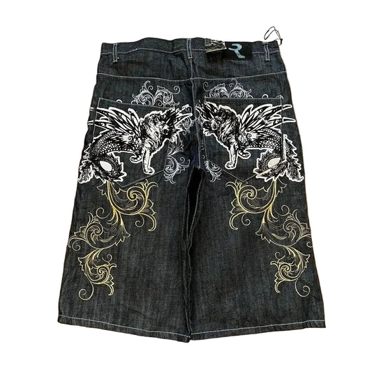 Denim shorts with wolf and floral embroidery on a wooden floor