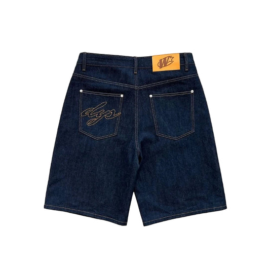 Dark blue denim shorts with brand logo on a gray concrete surface