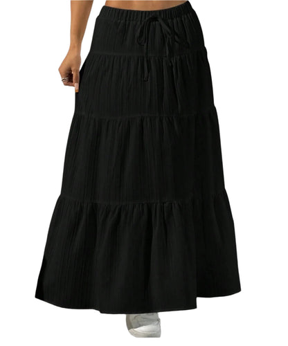 Black tiered skirt worn by a person on a plain background