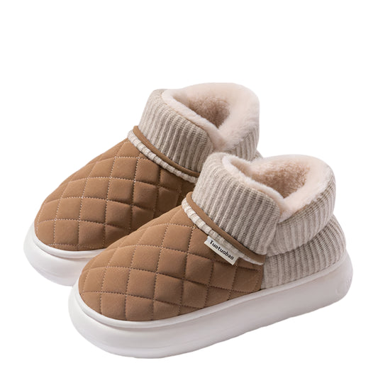 Pair of brown quilted slippers with white sole on a beige background