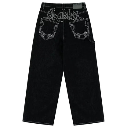 Black jeans with white embroidery on a white background