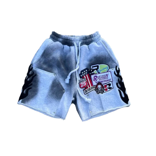 Gray shorts with patches on a cracked pavement background