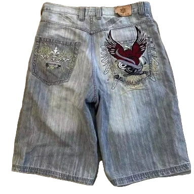 Denim shorts with embroidered designs on a wooden floor