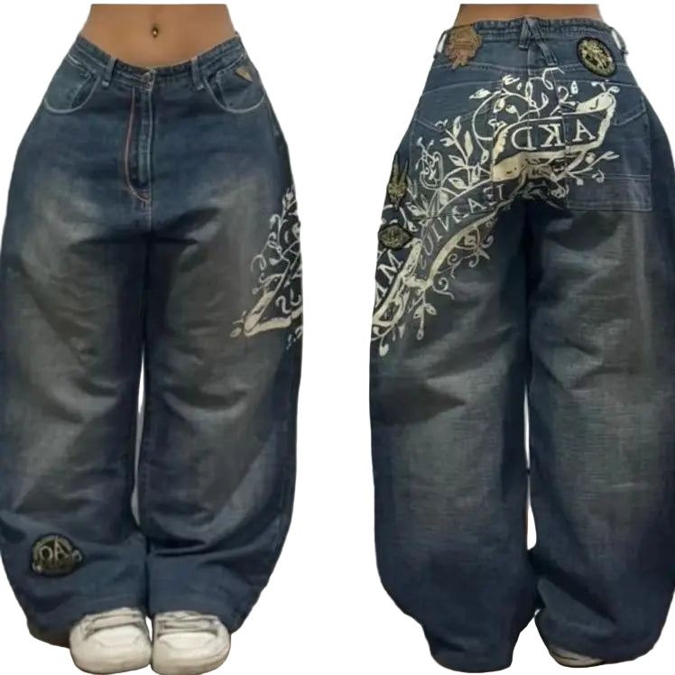 Pair of blue jeans with white embroidery on a neutral background
