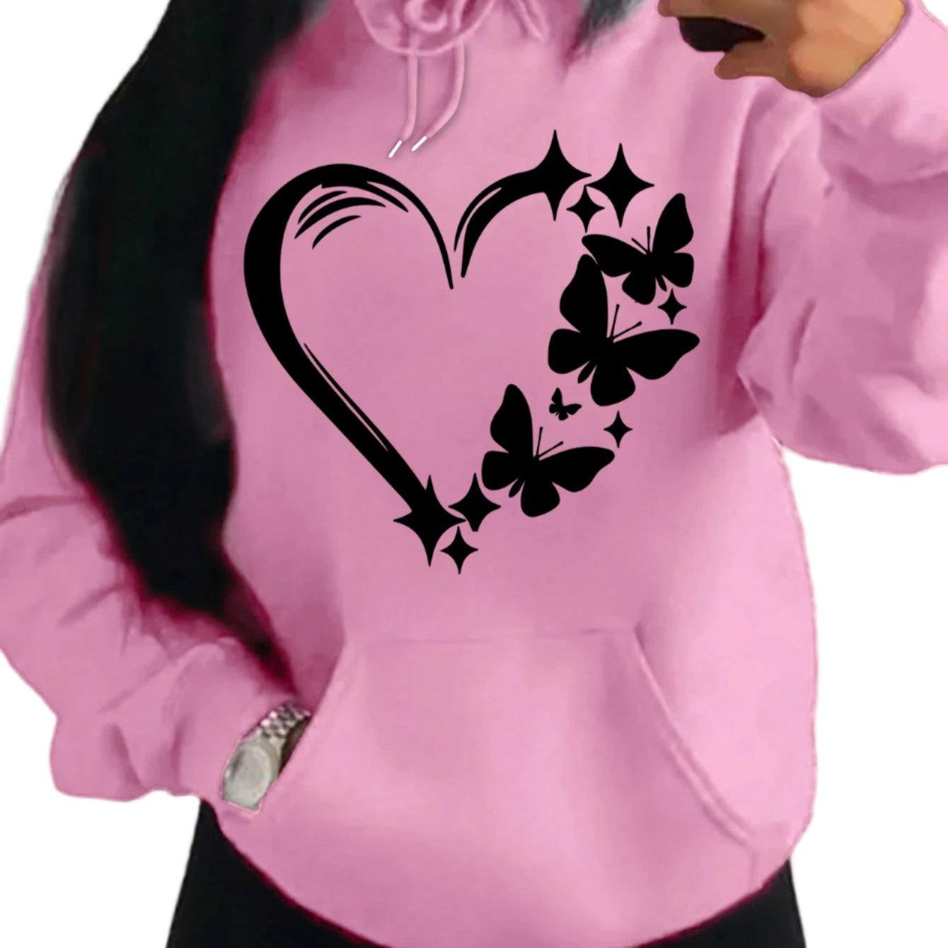Pink hoodie with black heart and butterfly design worn by a person.