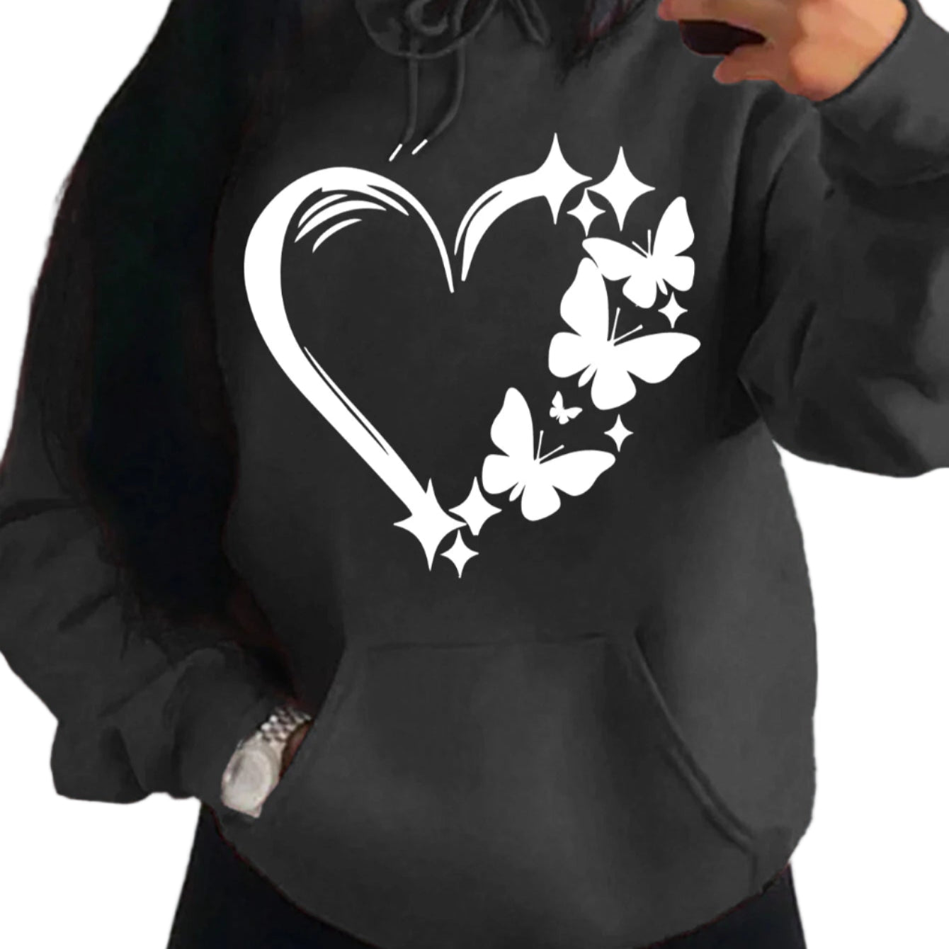 Person wearing a black hoodie with a white heart and butterfly design.
