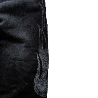 Close-up of textured fabric with a flame design on a dark background