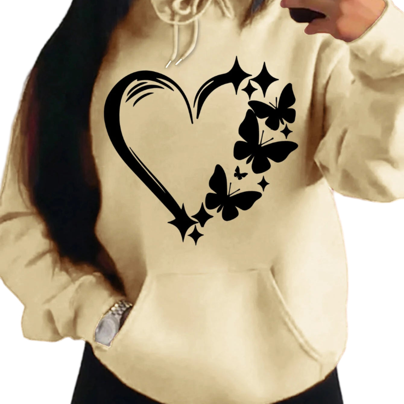 Beige hoodie with black heart and butterfly design worn by a person.