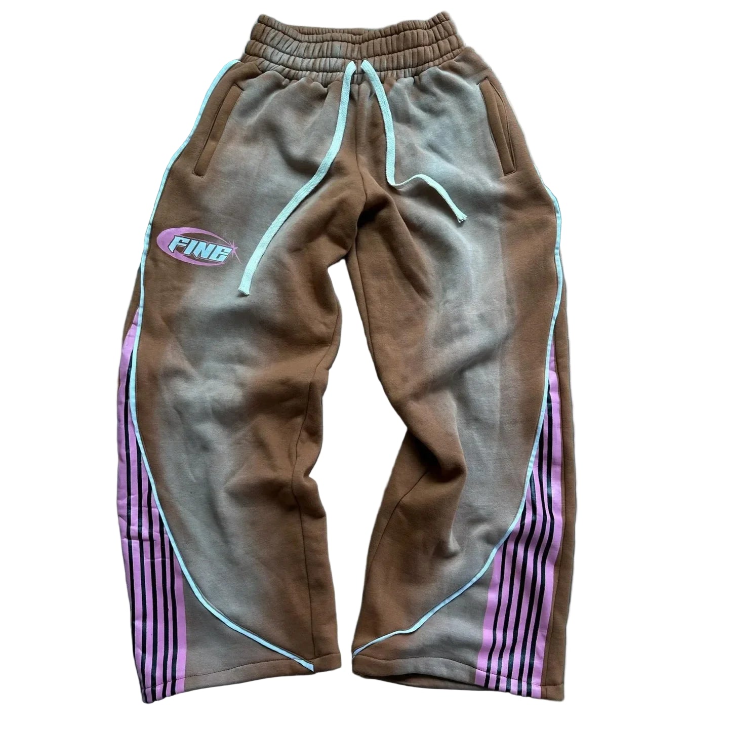 Brown tracksuit pants with pink stripes on a dark wooden surface