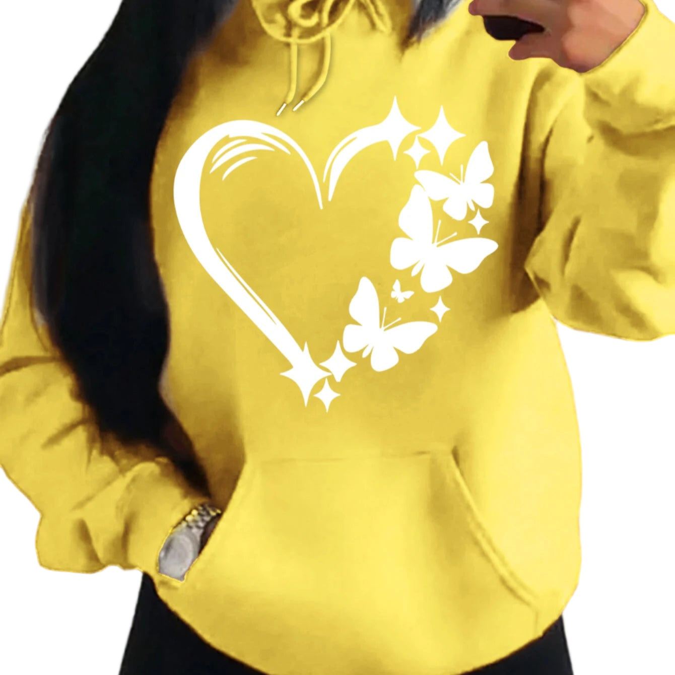 Yellow hoodie with a heart and butterfly design worn by a person.