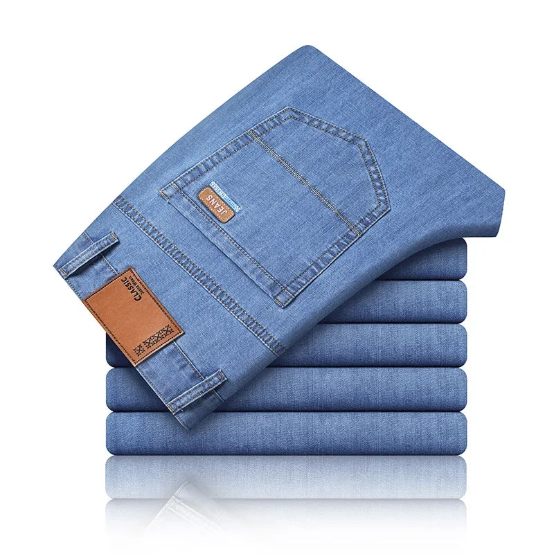 Stack of folded blue jeans with a brand tag on a white background
