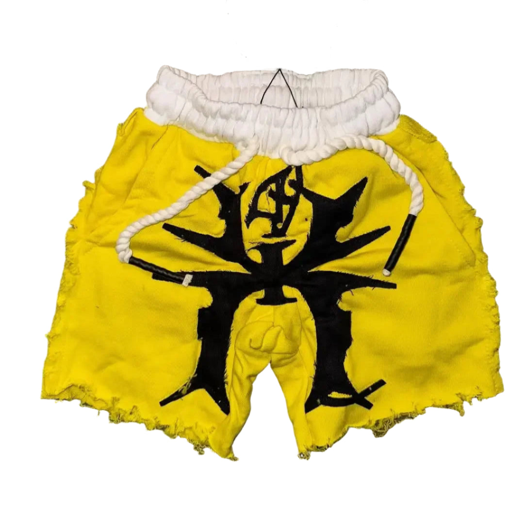 Yellow shorts with black design and white drawstring on a gray surface