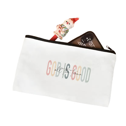 White pouch with 'GOD IS GOOD all the time' text on a light pink surface.