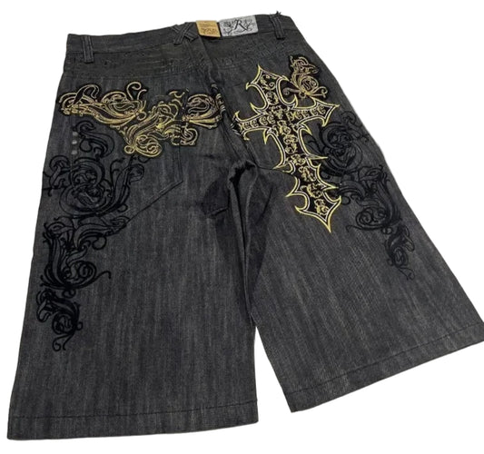 Denim shorts with intricate gold and black embroidery on a white background