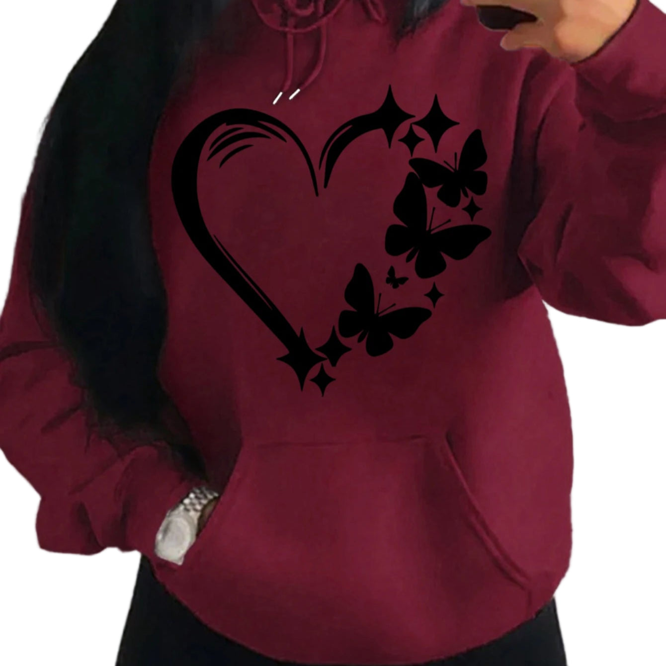 Person wearing a maroon hoodie with black heart and butterfly design.